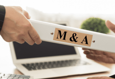 M&A binder being passed across a desk